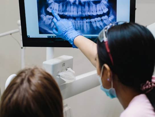 Dentist reviewing a dental X-ray with a patient at a dental clinic in Jayanagar.